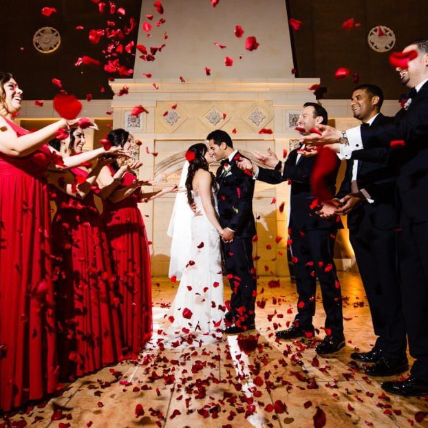 wedding flowers being tossed behind a newlywed couple